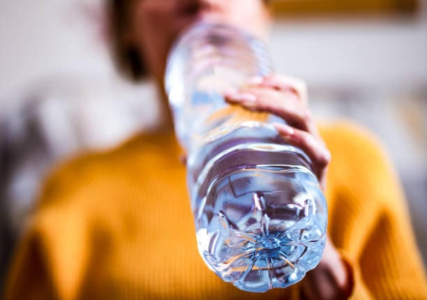 vrouwen drinkwater in een plastic fles